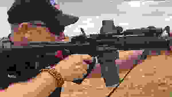 Marksman in a Black Baseball Cap Shooting a Sporting Rifle